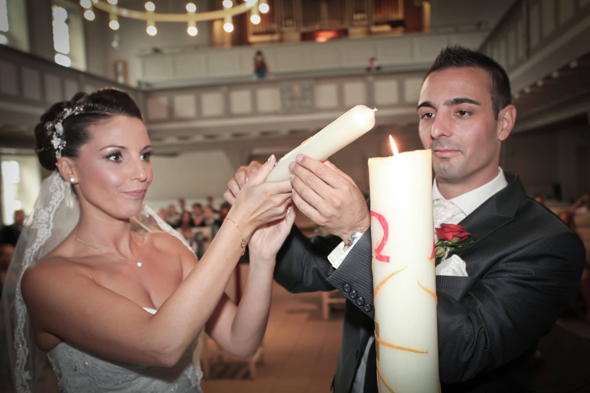 Brautpaar entzündet gemeinsam die Hochzeitskerze am Altar während der Trauung