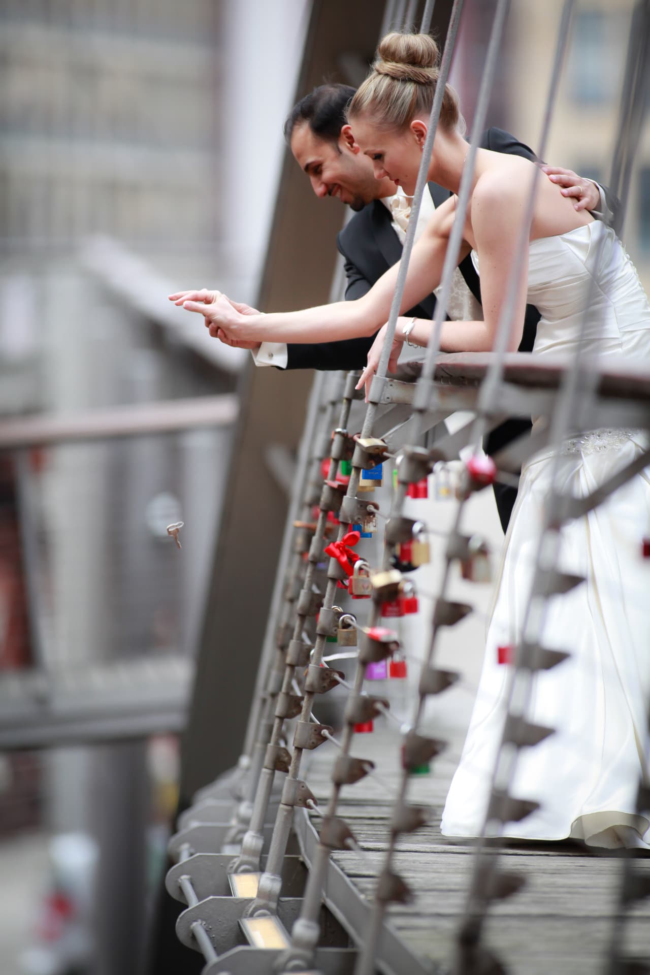 Brautpaar wirft den Schlüssel des Liebesschlosses von einer Brücke, Hochzeitsfotograf Hamburg