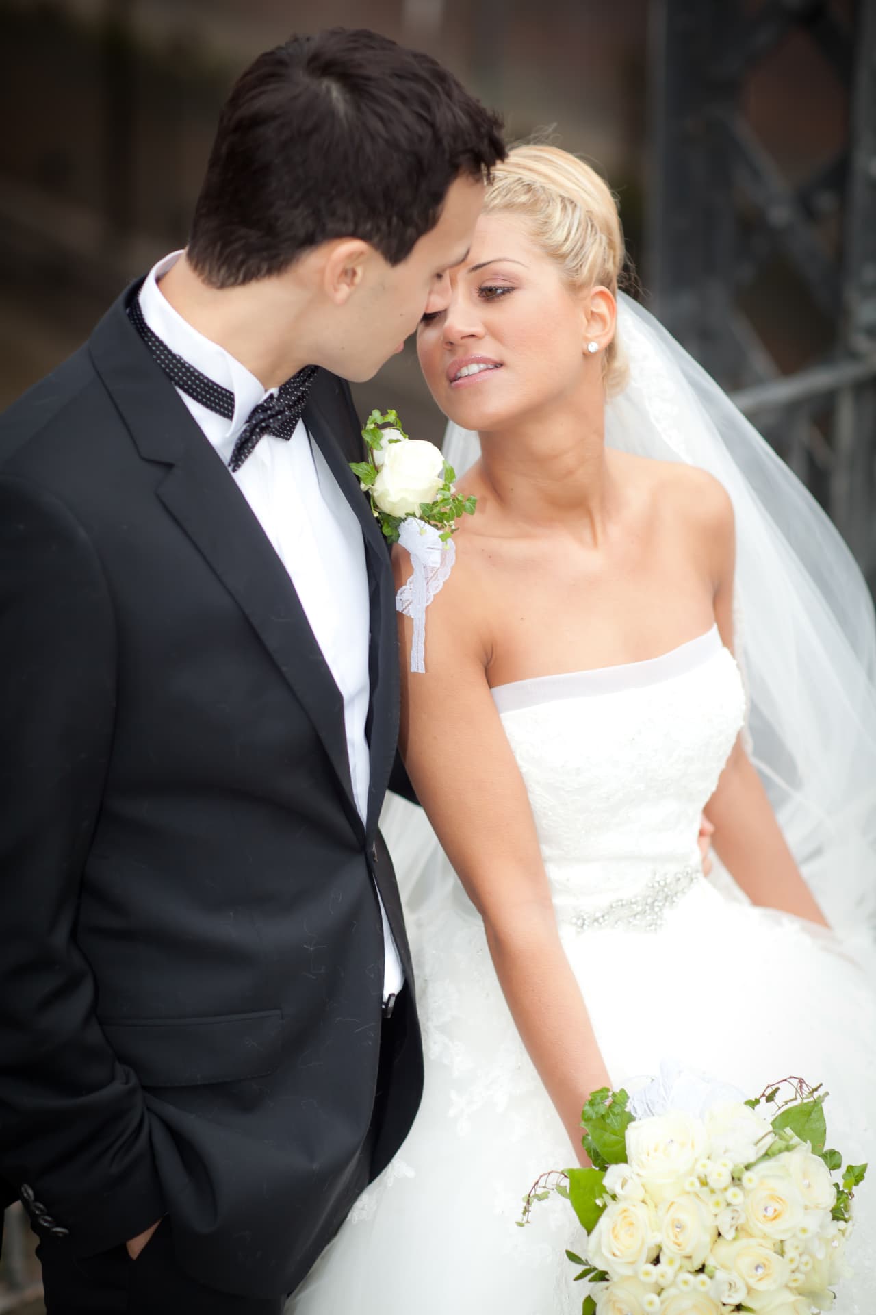 Brautpaar Stirn an Stirn, Braut im Spitzenkleid mit Schleier und Rosenstrauß, Hochzeitsfotograf Hamburg